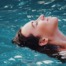 Woman floating iand relaxing in clear water